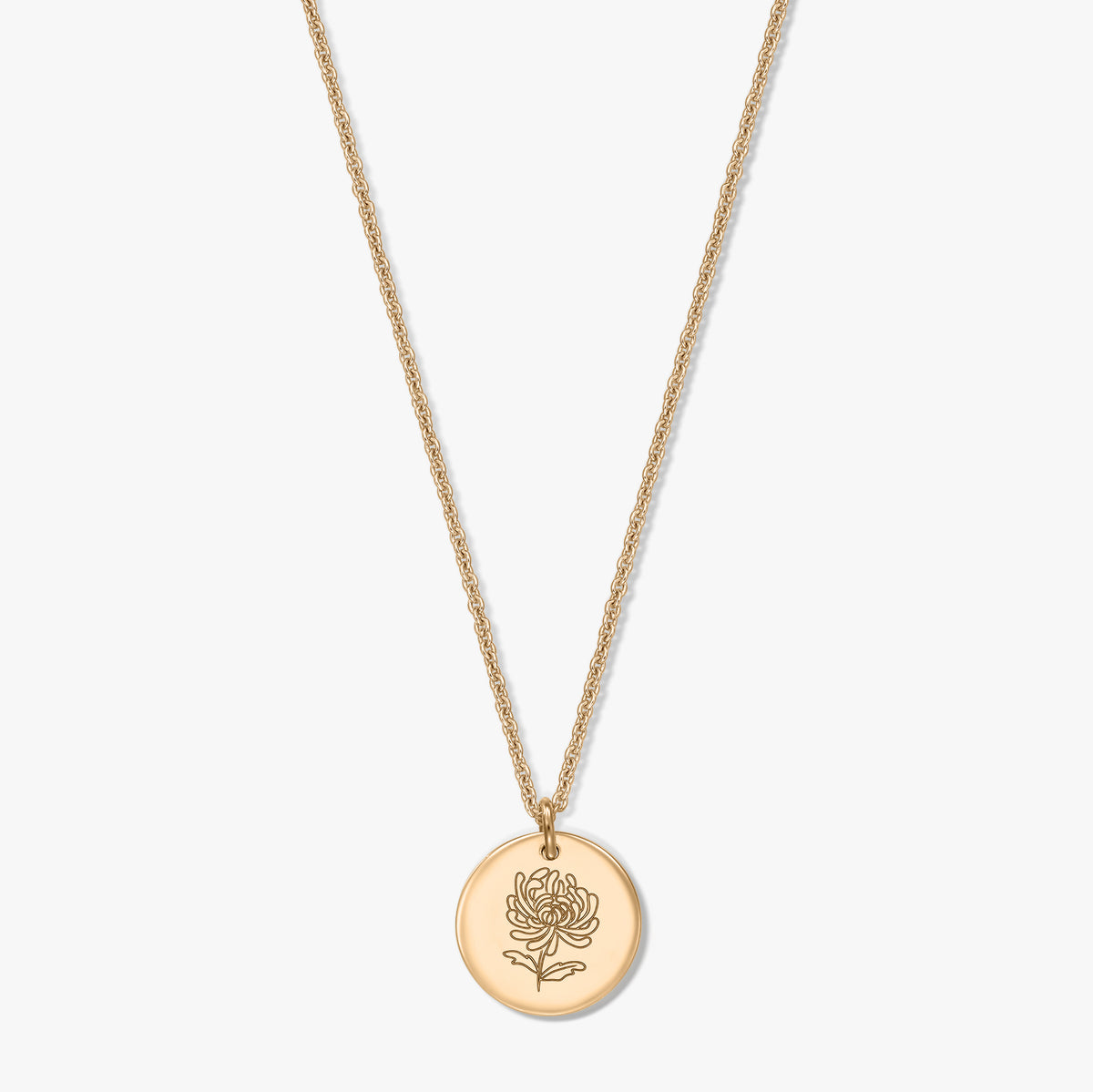 Collier en argent plaqué or avec pendentif rond en forme de pièce, gravé d’un chrysanthème, la fleur de naissance de novembre, sur fond blanc.