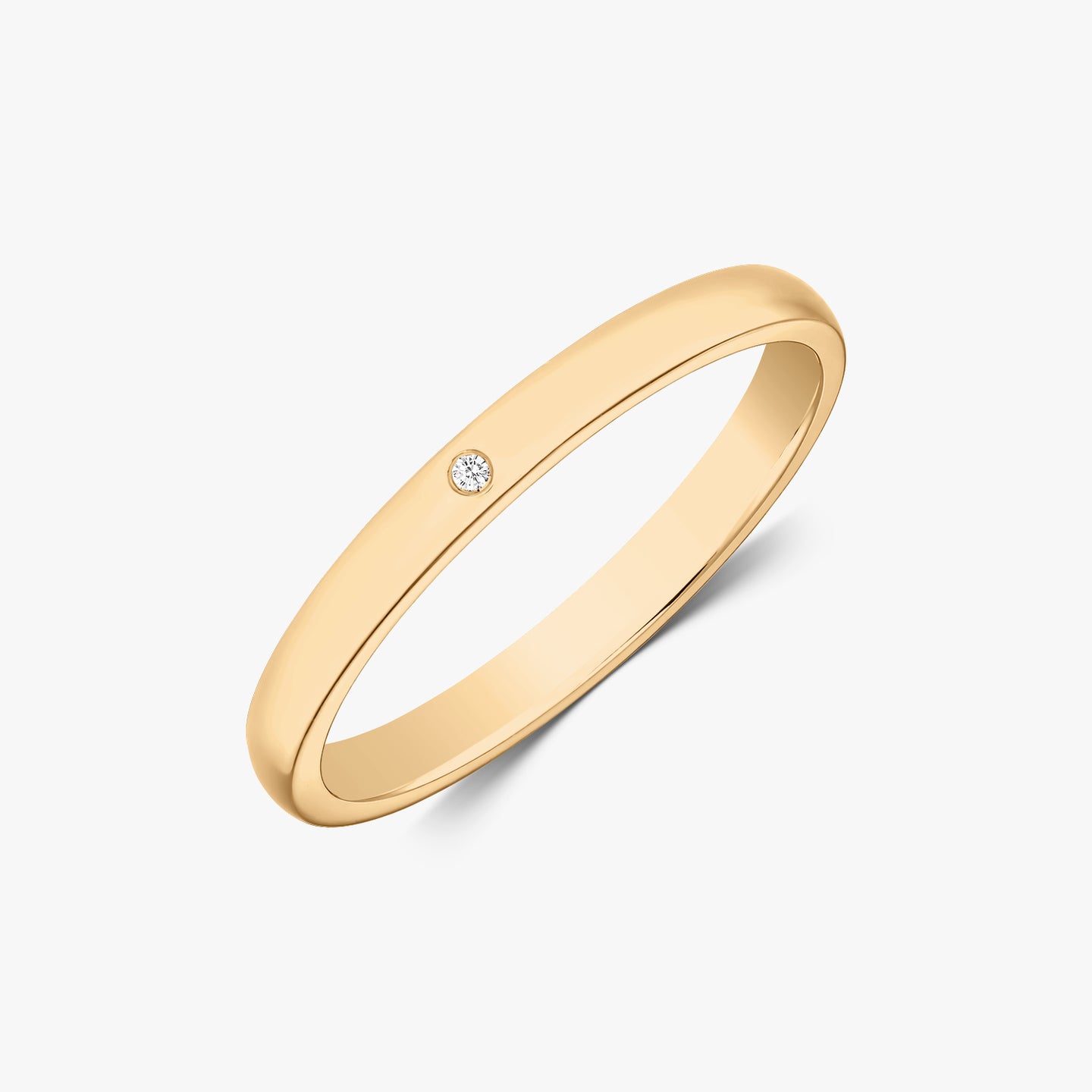 Fine alliance en or arrondi avec un petit diamant sur fond blanc.