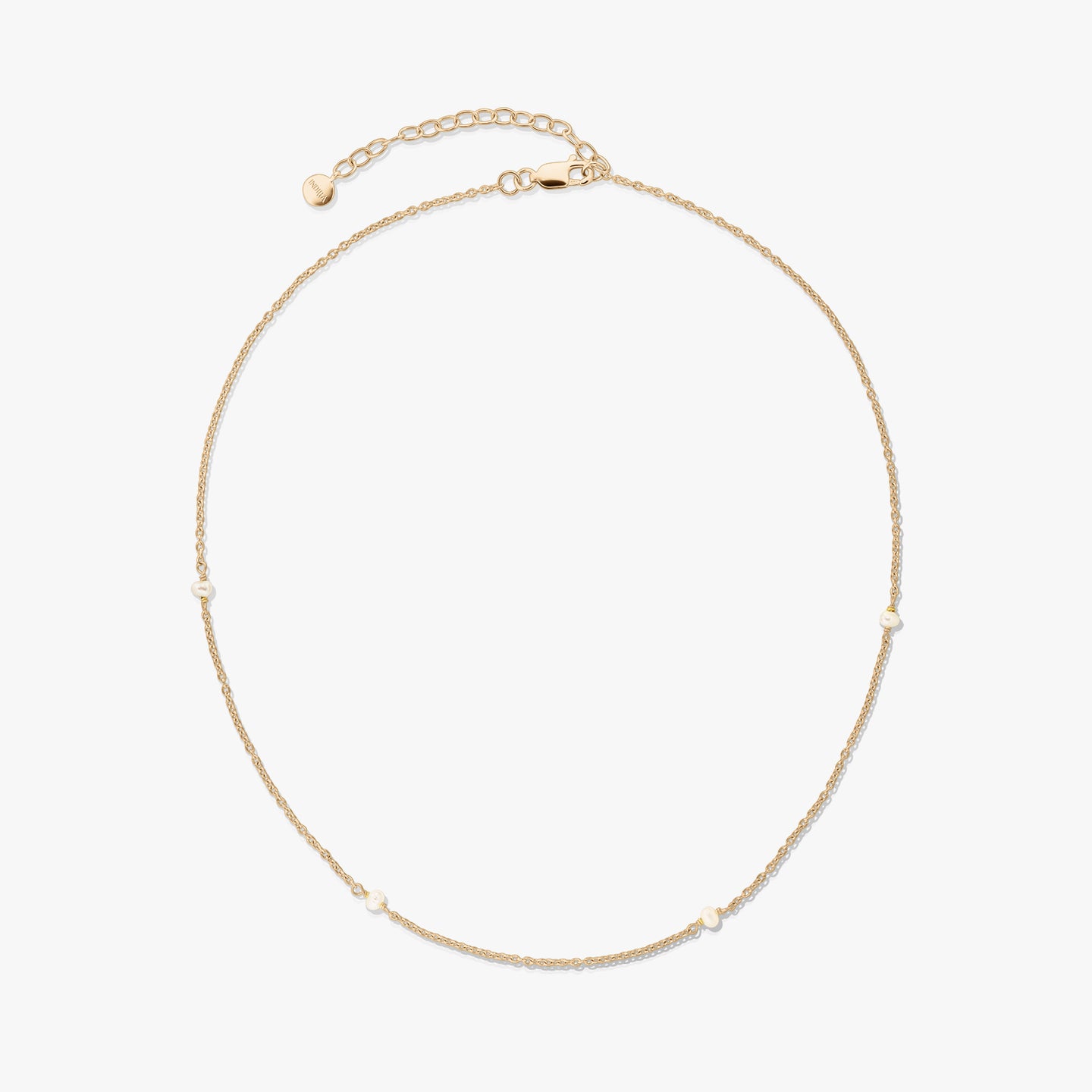 Collier délicat en argent 925 plaqué or avec de petites perles naturelles et une rallonge réglable avec fermoir mousqueton, sur fond blanc.