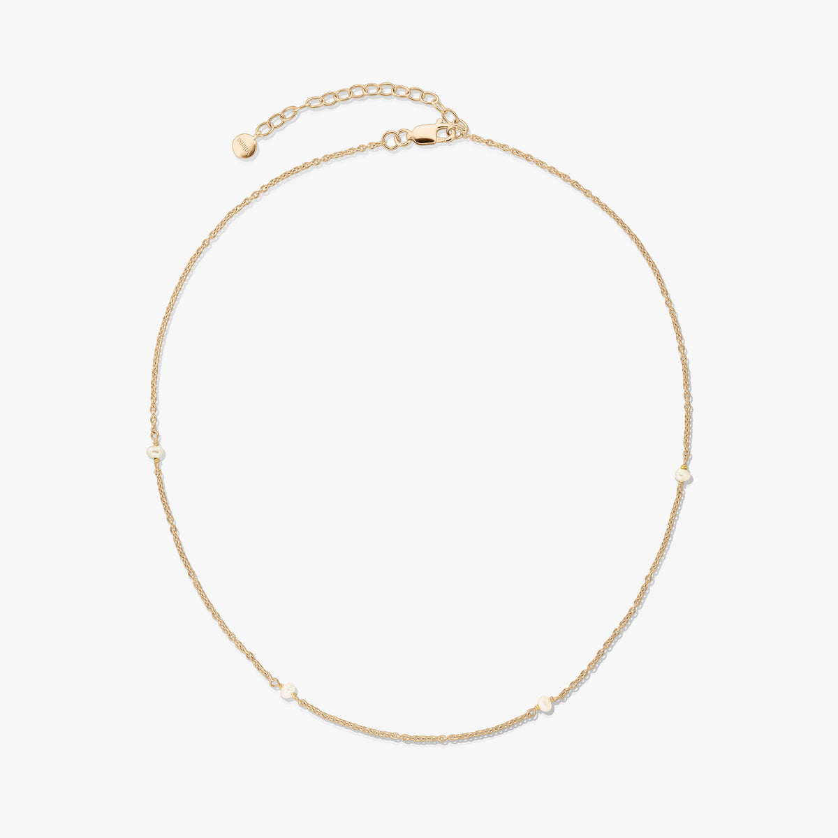 Collier délicat en argent 925 plaqué or avec de petites perles naturelles et une rallonge réglable avec fermoir mousqueton, sur fond blanc.