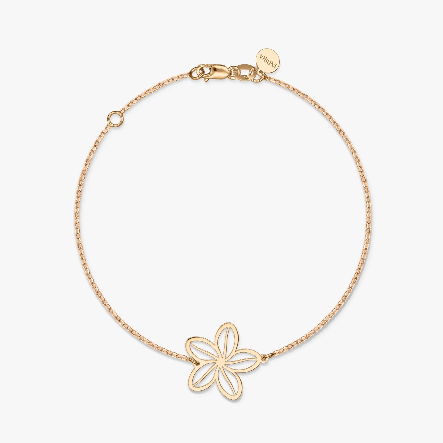 Un bracelet minimaliste en or avec un charm fleur délicat sur un fond blanc uni.