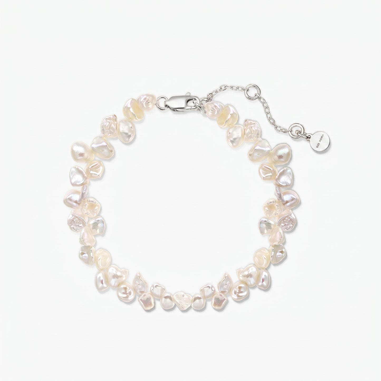 Bracelet ajustable en perles keshi d’eau douce, doté d’un fermoir mousqueton en argent 925 plaqué rhodium et d’une chaîne d’extension, sur fond blanc.