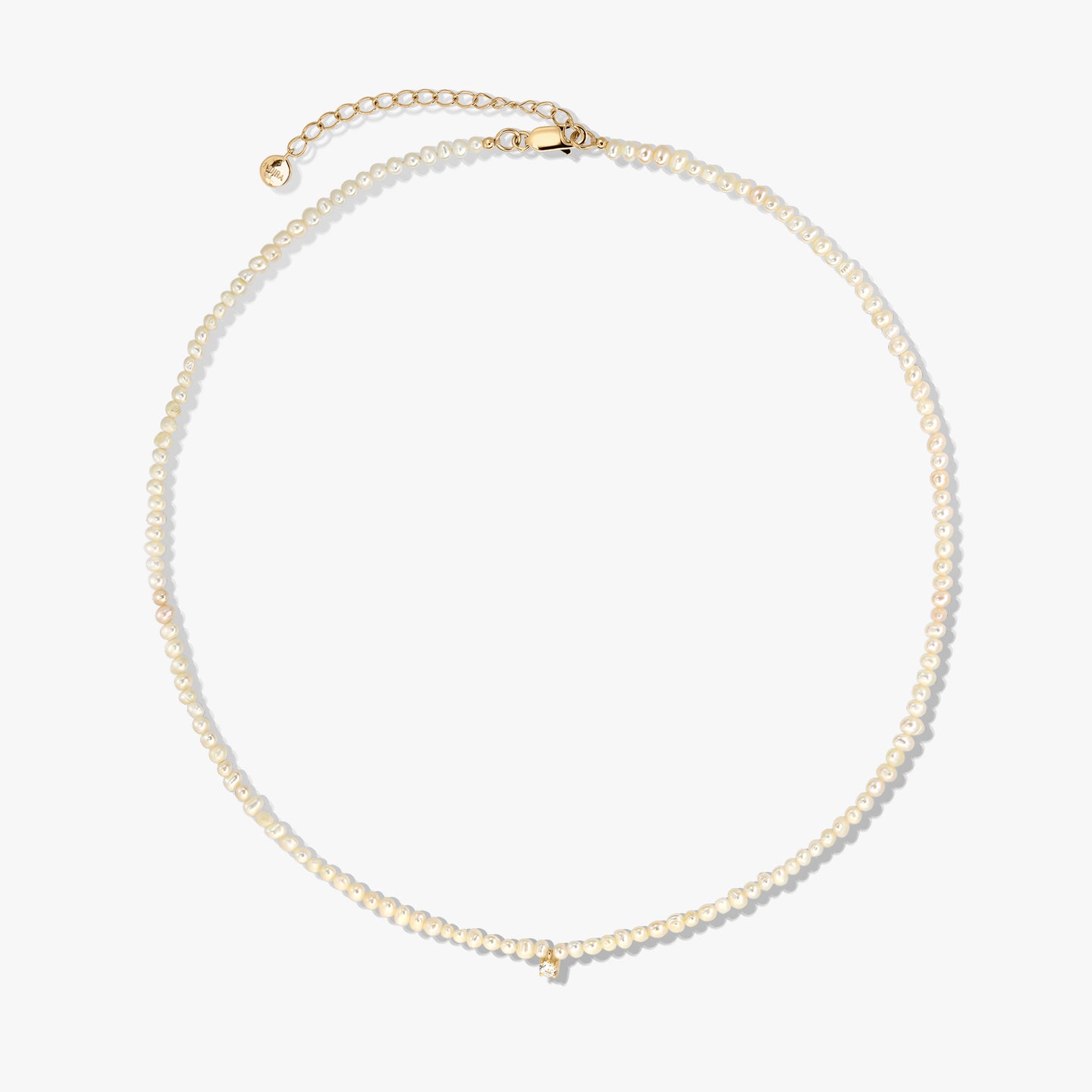 Collier délicat de perles de culture avec fermoir et chaînette d’extension en argent sterling plaqué or, photographié sur fond blanc.