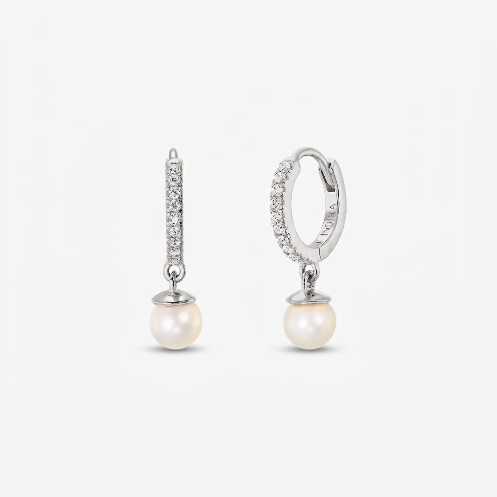 Paire de créoles en argent pavées de zirconia, agrémentées de perles naturelles blanches rondes pendantes, sur fond blanc.