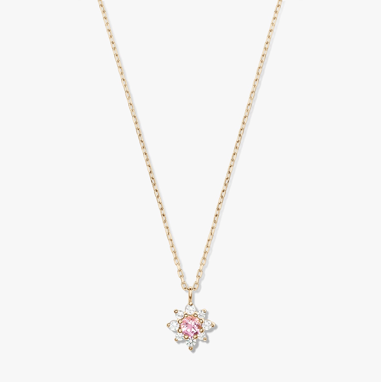 Collier en or jaune 14K avec chaîne délicate et pendentif floral, doté d’une morganite rose centrale entourée de saphirs blancs, sur fond blanc.