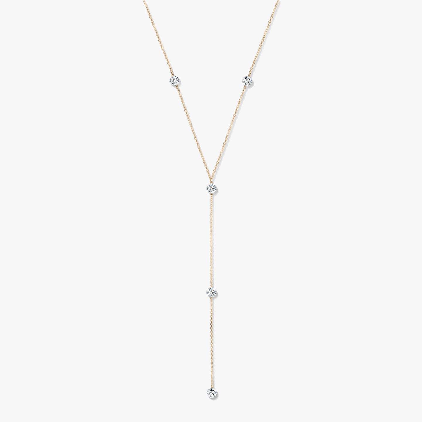 Collier lariat en or jaune 14K avec cinq diamants ronds sertis clos, sur fond blanc.