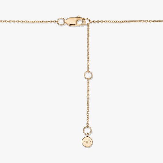 Gros plan d’un fermoir de collier en argent sterling plaqué or avec une chaînette d’extension réglable et un petit médaillon rond gravé « INDIRA », sur fond blanc.
