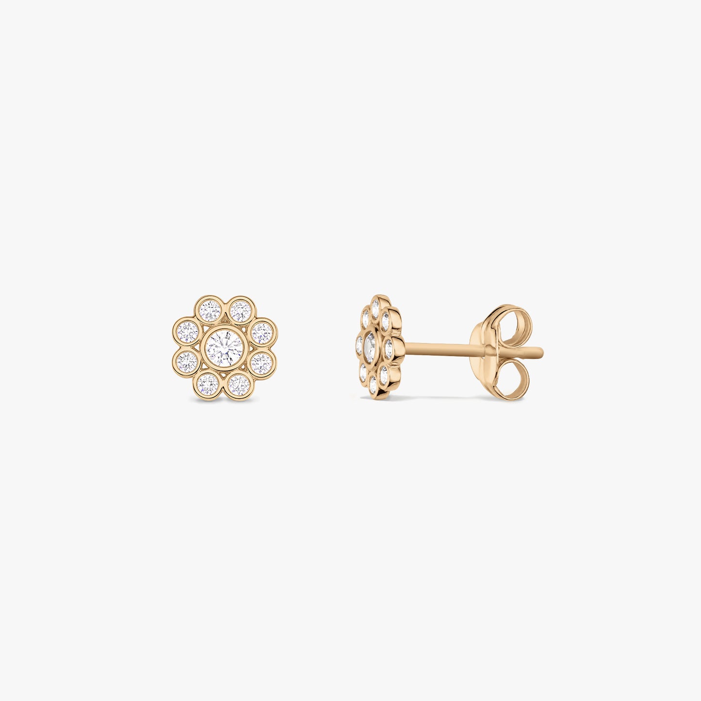 Paire de puces d’oreilles en or jaune 14 K en forme de marguerite, serties d’oxyde de zirconium blanc, présentées de face et de profil sur fond blanc.