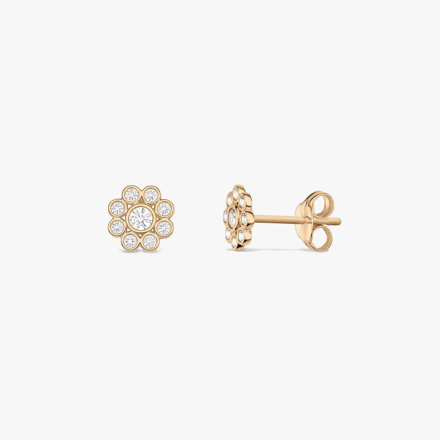Paire de puces d’oreilles en or jaune 14 K en forme de marguerite, serties d’oxyde de zirconium blanc, présentées de face et de profil sur fond blanc.