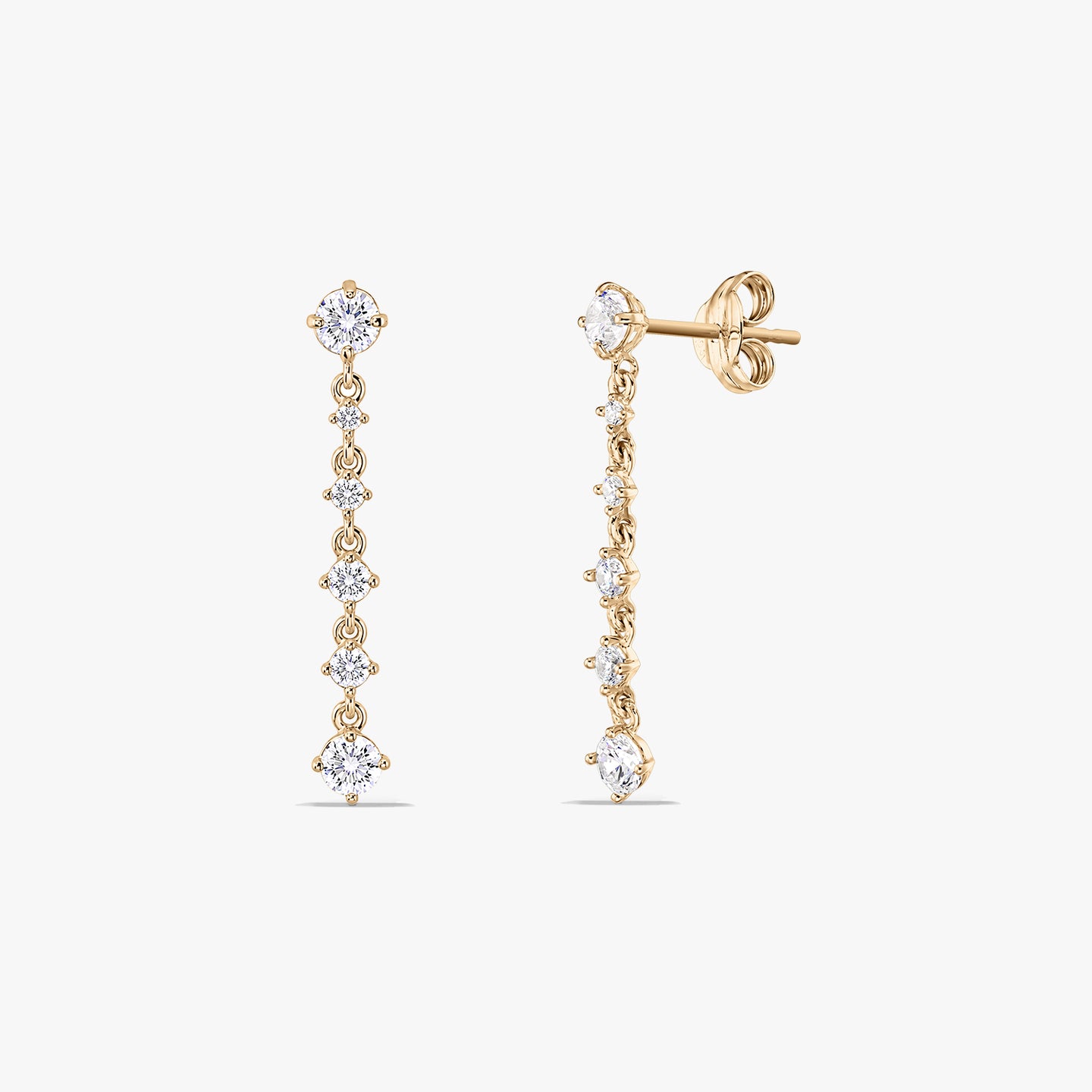 Paire de boucles d'oreilles pendantes en or jaune 14K, ornées d'une ligne verticale de zircones cubiques rondes blanches. L'une est montrée de face et l'autre en angle pour révéler la tige et le fermoir papillon, sur fond blanc.