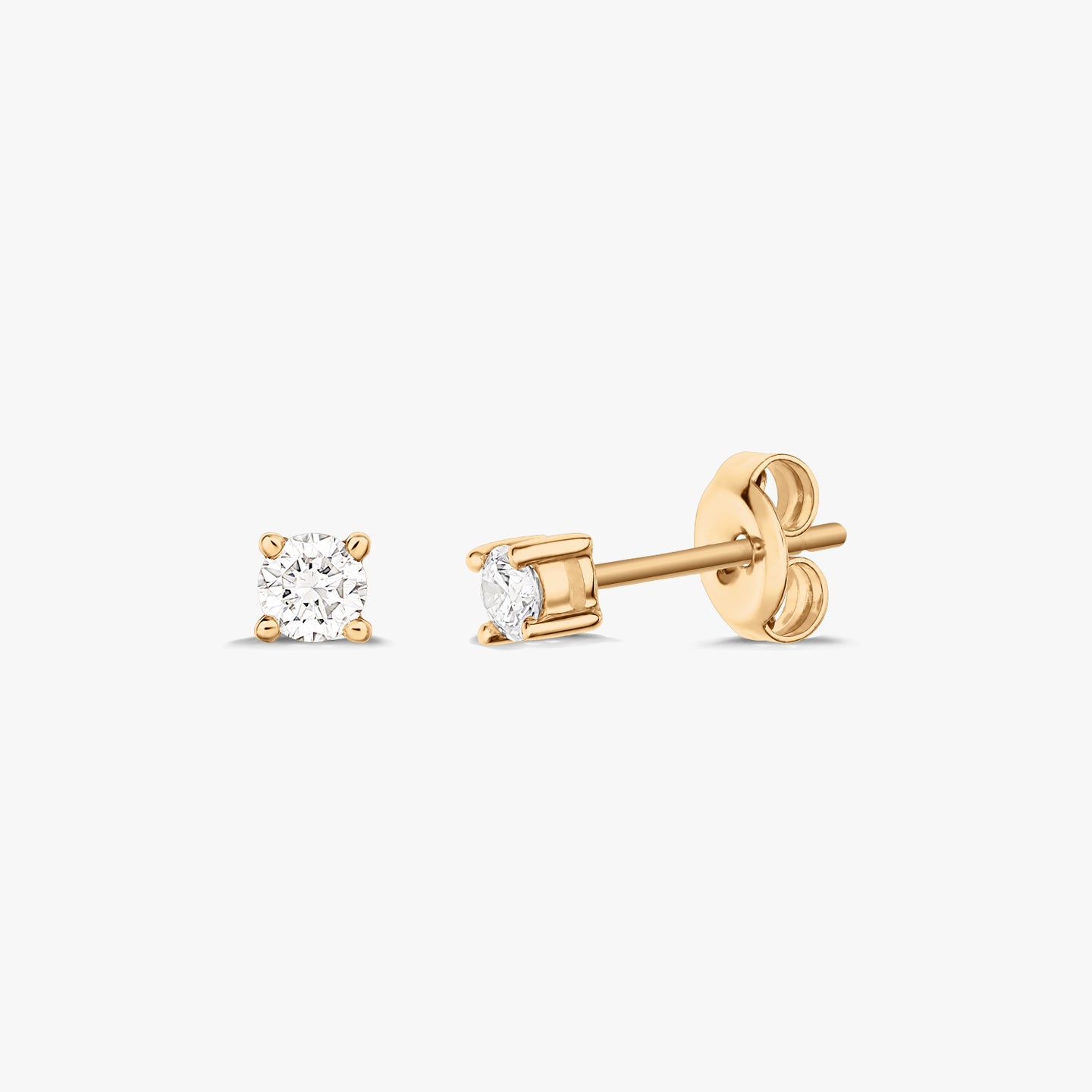Paire de boucles d'oreilles en or avec diamant solitaire, présentées sur fond blanc.