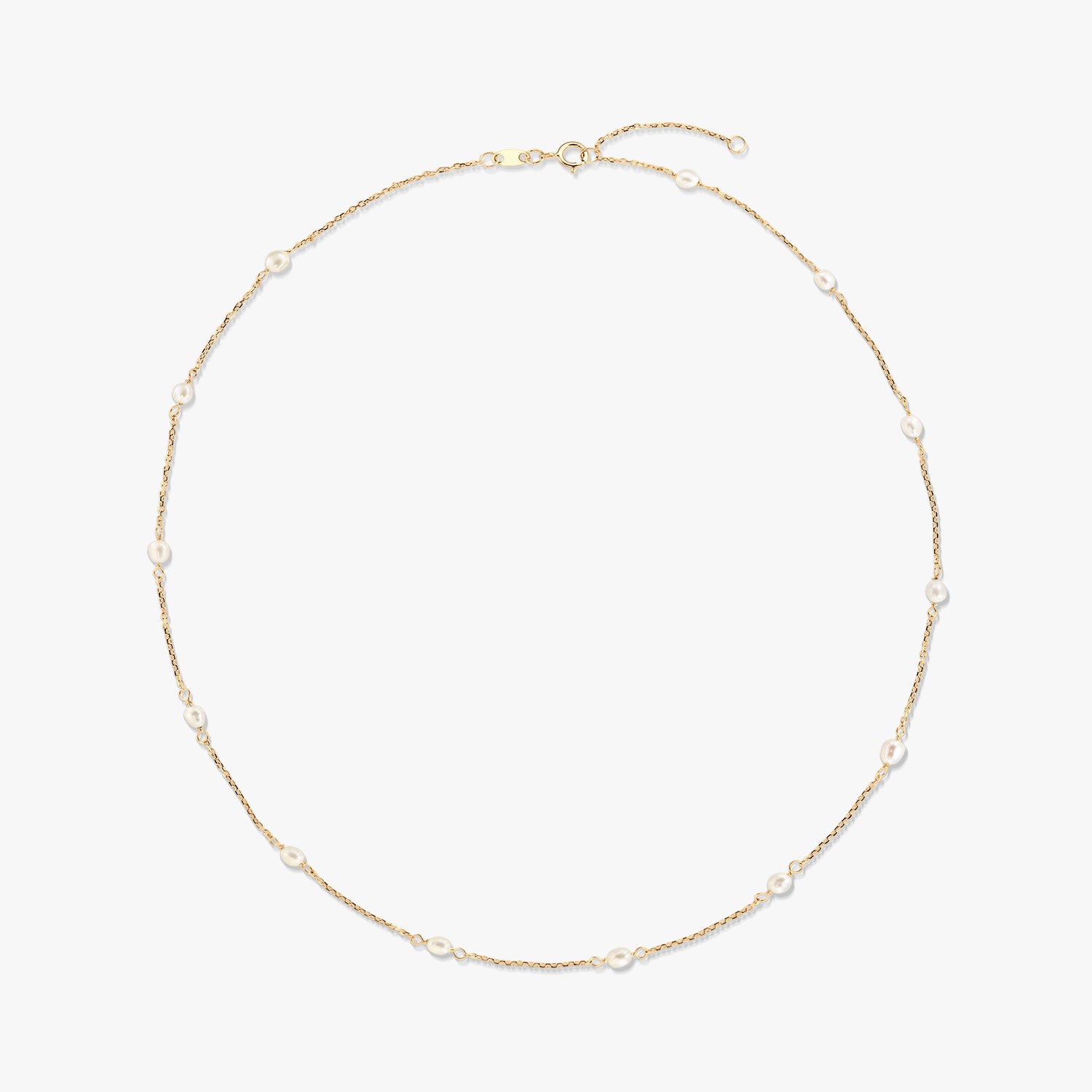 Collier station en or jaune 14K avec de petites perles blanches naturelles espacées le long d’une fine chaîne, isolé sur fond blanc.