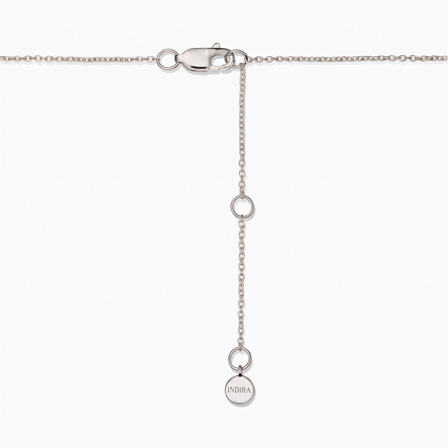 Gros plan sur le fermoir d'un collier en argent sterling avec chaîne d'extension réglable et une petite pastille ronde Indira, sur fond blanc.