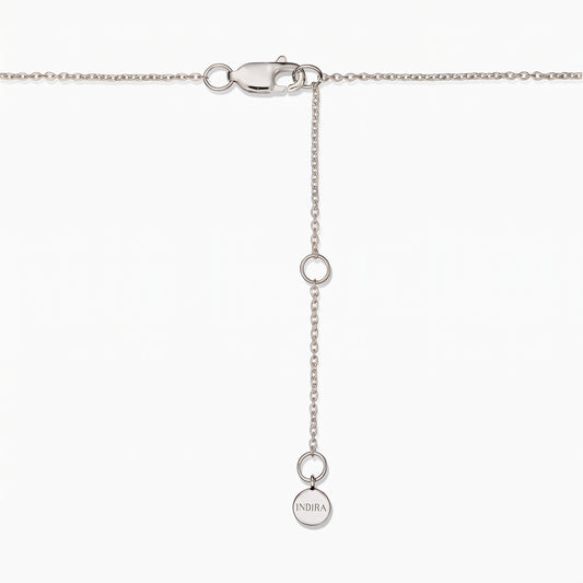 Gros plan sur le fermoir d'un collier en argent sterling avec chaîne d'extension réglable et une petite pastille ronde Indira, sur fond blanc.