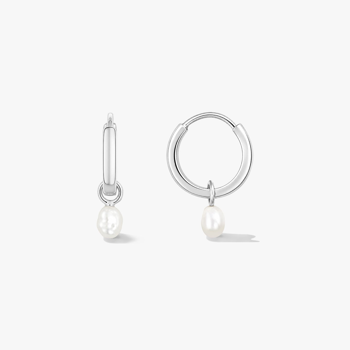 Paire de créoles en argent sterling avec de petites perles naturelles pendantes sur fond blanc, l’une vue de face et l’autre de côté.