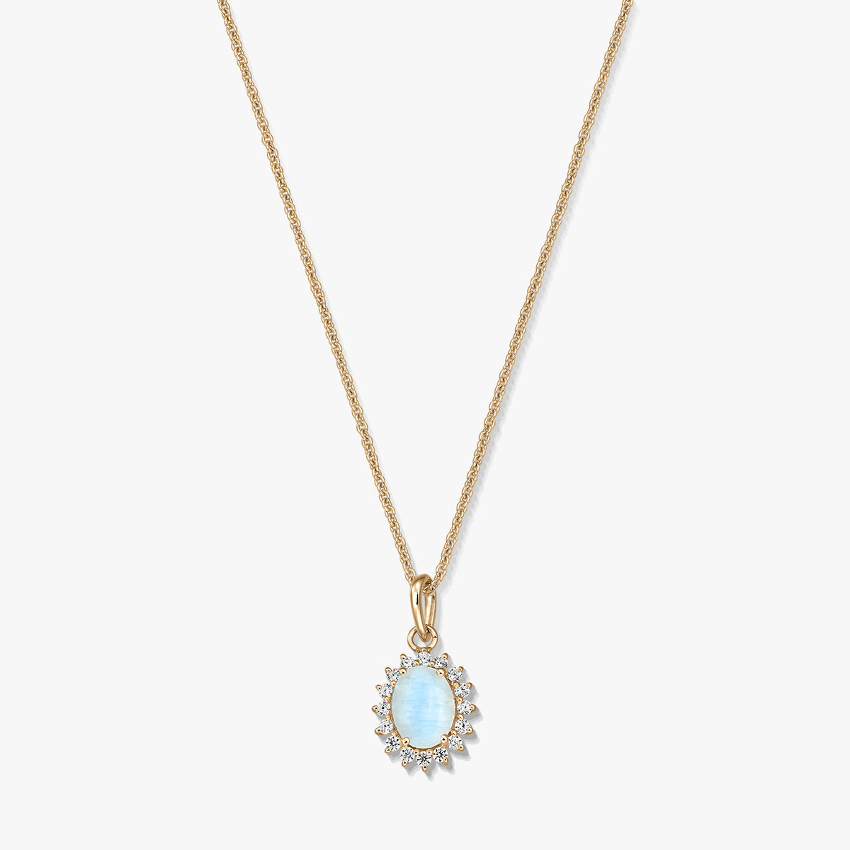 Collier en argent sterling plaqué or avec pendentif ovale en pierre de lune bleu clair, encadré de petites pierres transparentes, sur fond blanc.