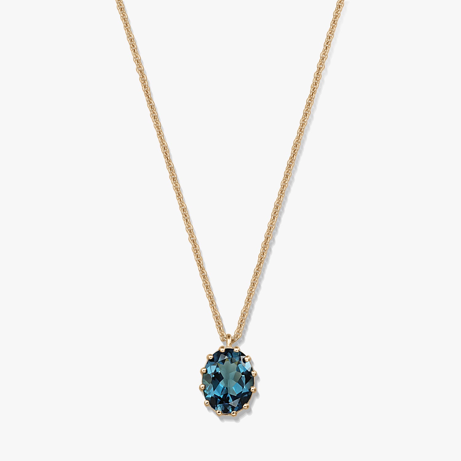 Collier en argent sterling plaqué or avec pendentif ovale en topaze bleu London, sur fond blanc.