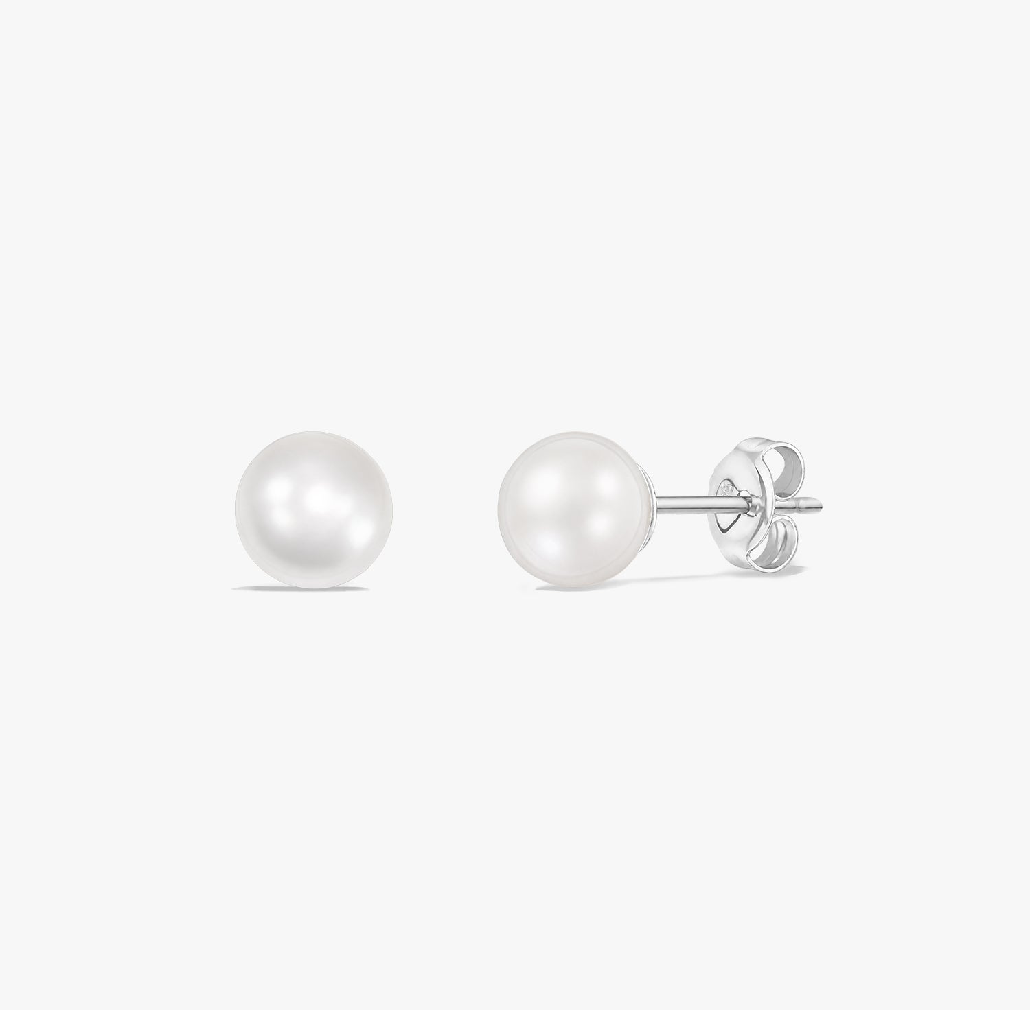 Paire de puces d’oreilles élégantes en perles blanches naturelles serties en argent sterling 925 sur fond blanc.