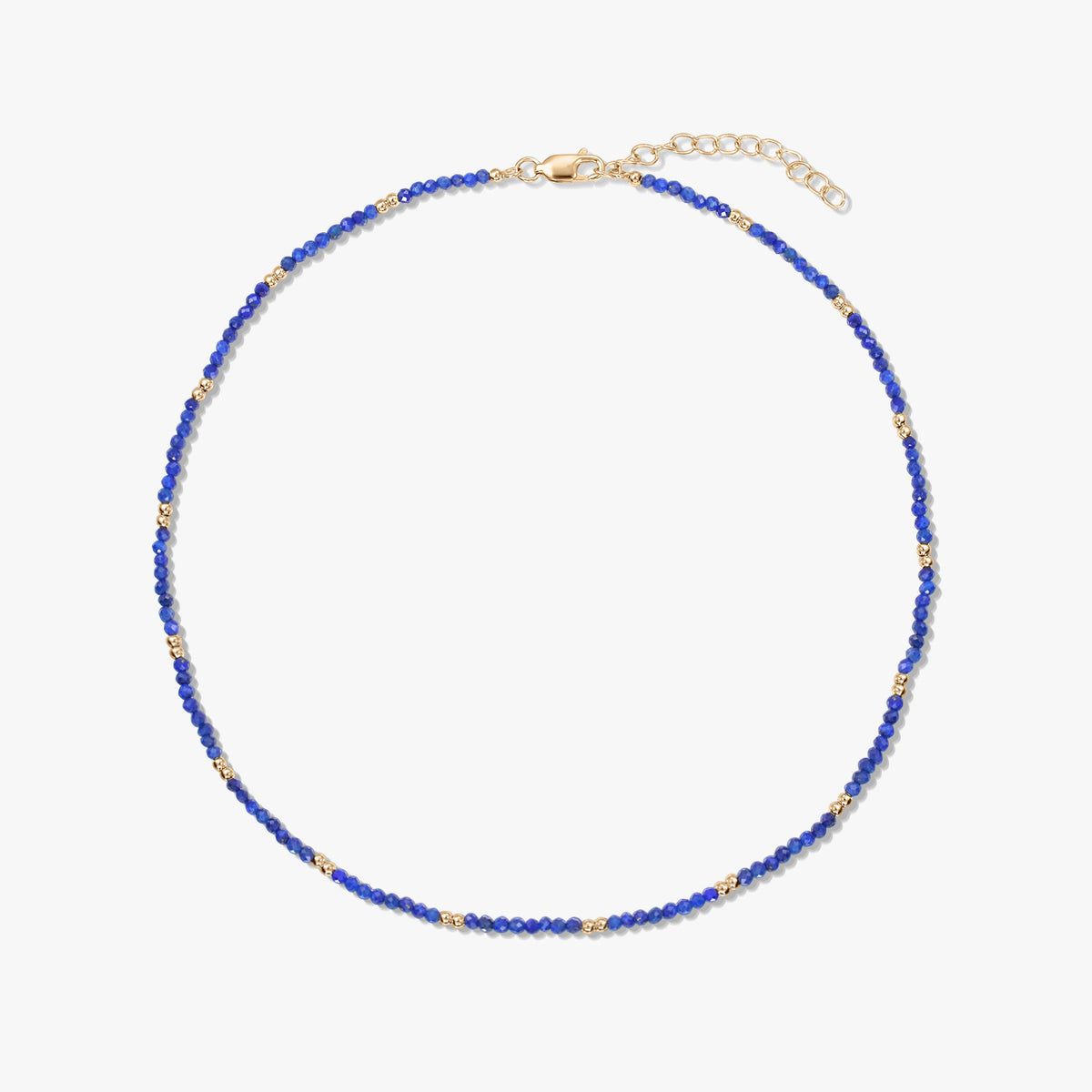 Collier délicat en perles de lapis-lazuli avec de petits détails en argent sterling plaqué or et un fermoir mousqueton réglable, isolé sur fond blanc.