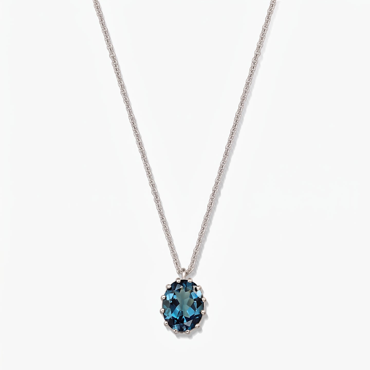 Collier en argent sterling avec un pendentif ovale en topaze bleu de Londres sur fond blanc.