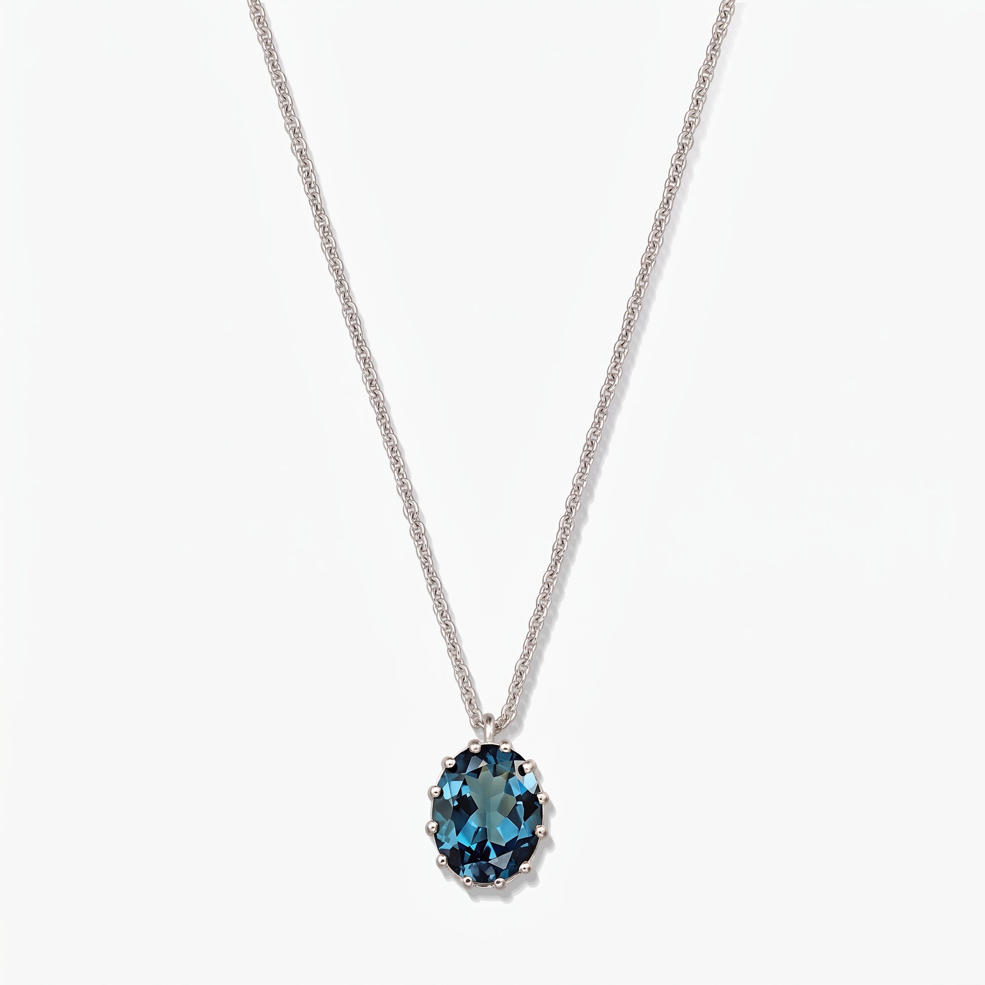 Collier en argent sterling avec un pendentif ovale en topaze bleu de Londres sur fond blanc.