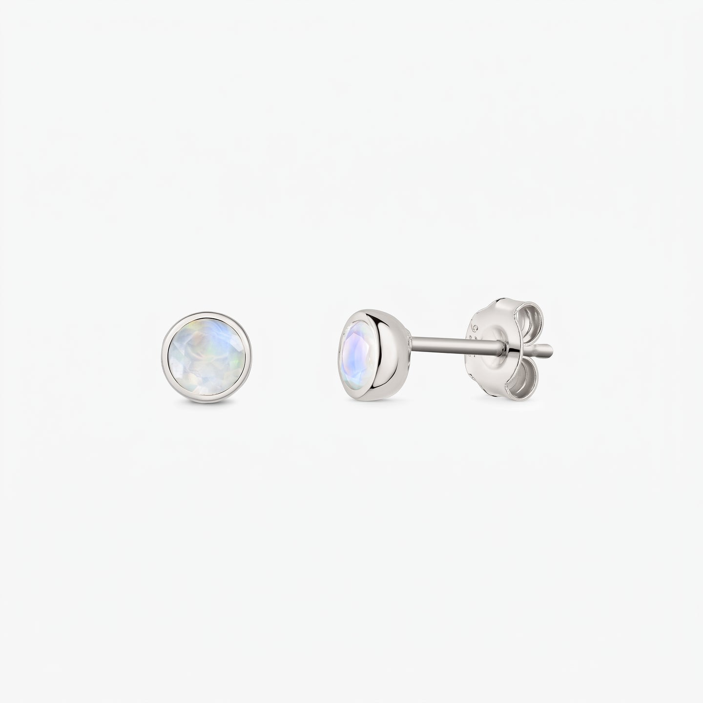 Paire de puces d’oreilles en pierre de lune en argent sterling 925 sur fond blanc, vues de face et de côté, avec fermoirs poussette et pierres rondes iridescentes serties en clos.