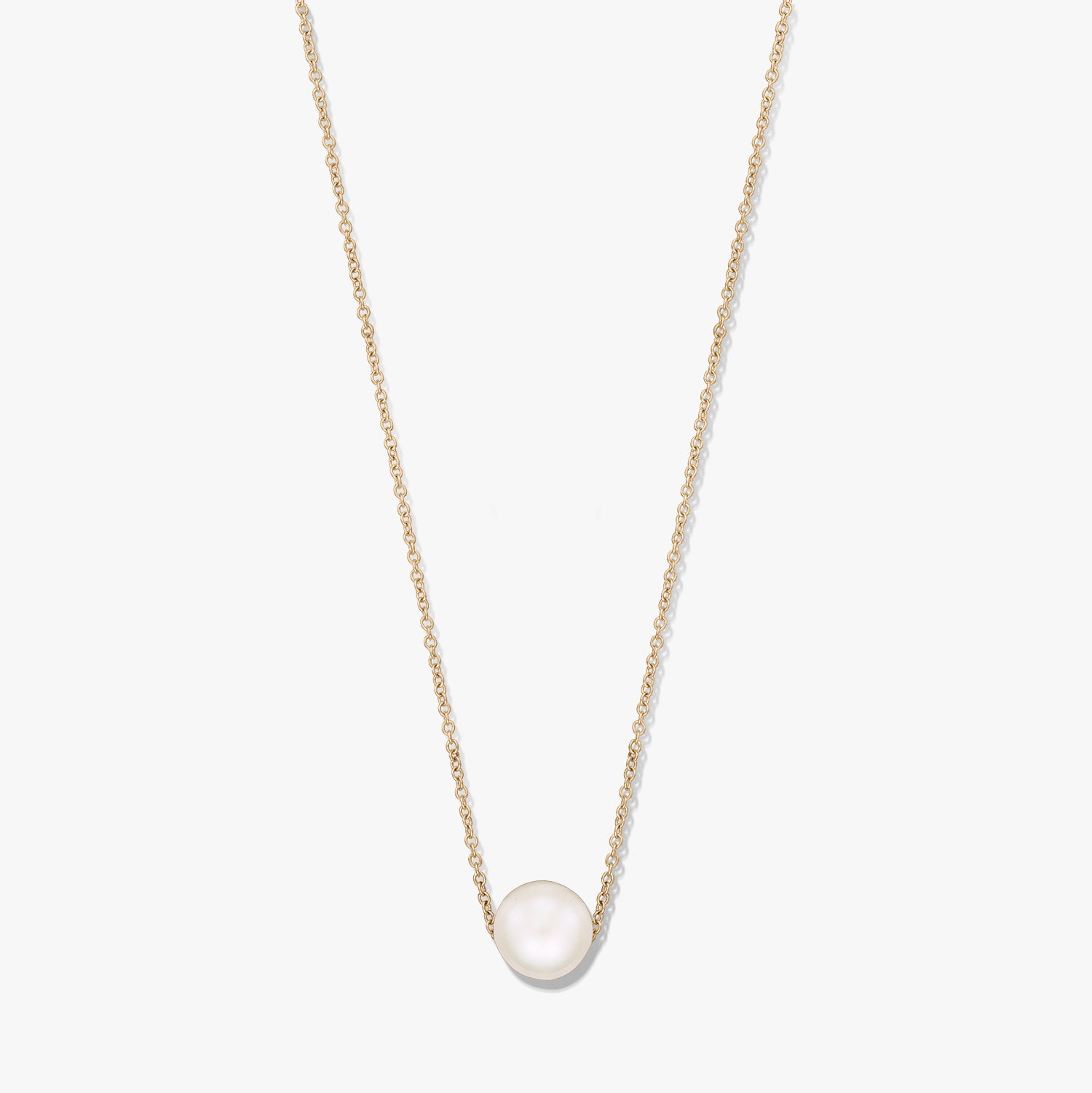 Collier à chaîne fine ton or avec une seule perle blanche naturelle centrée, isolé sur fond blanc.