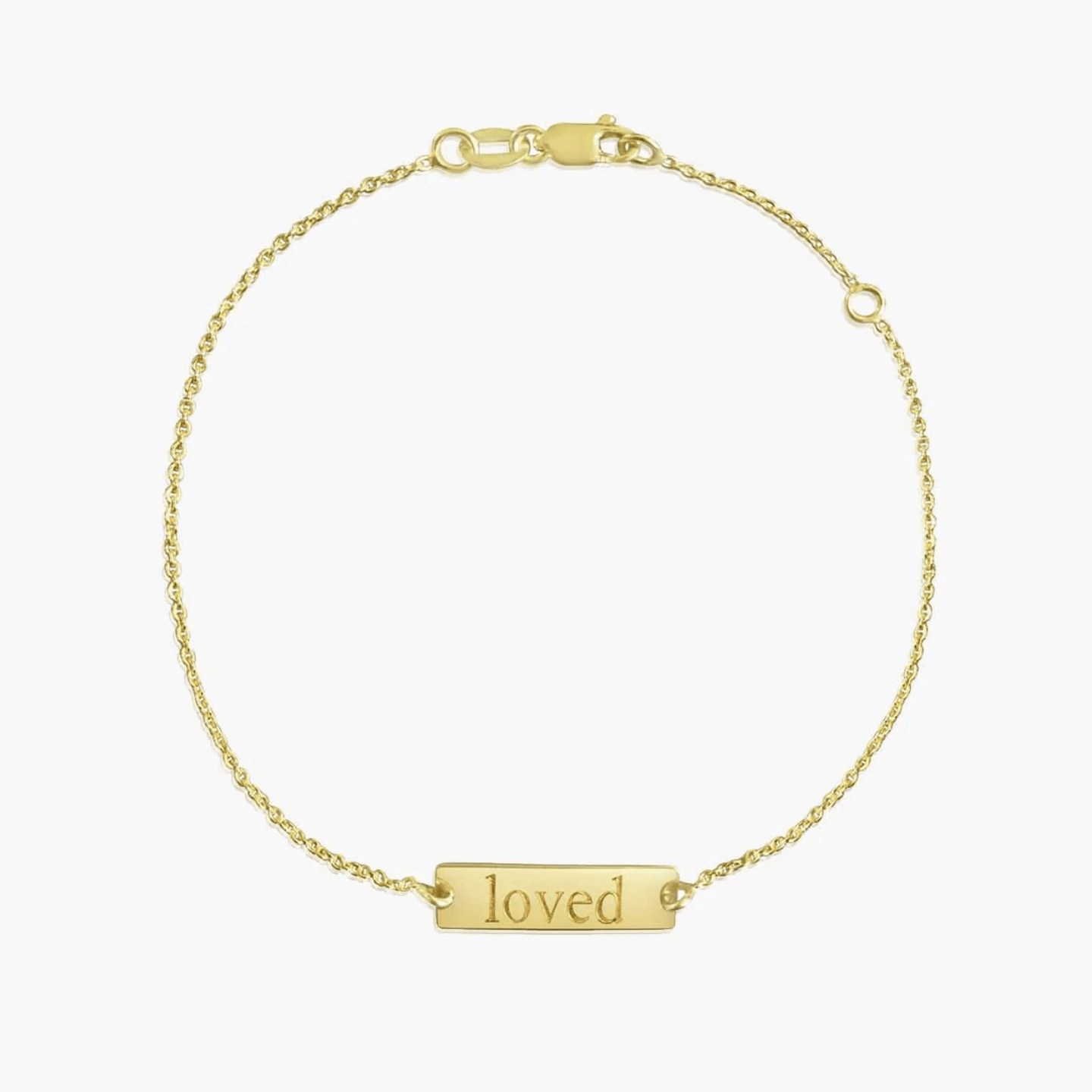 Bracelet en or 14 carats avec l'inscription « loved » sur un fond blanc uni.