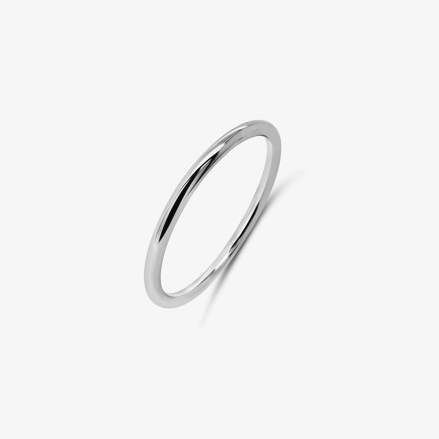 Une bague minimaliste en argent photographiée sur fond blanc.