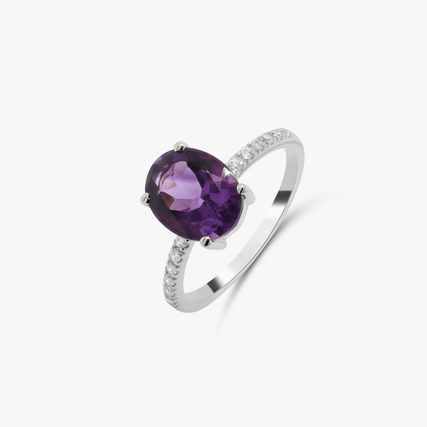 Bague en argent avec une améthyste violette et des accents de zirconium sur un fond blanc.