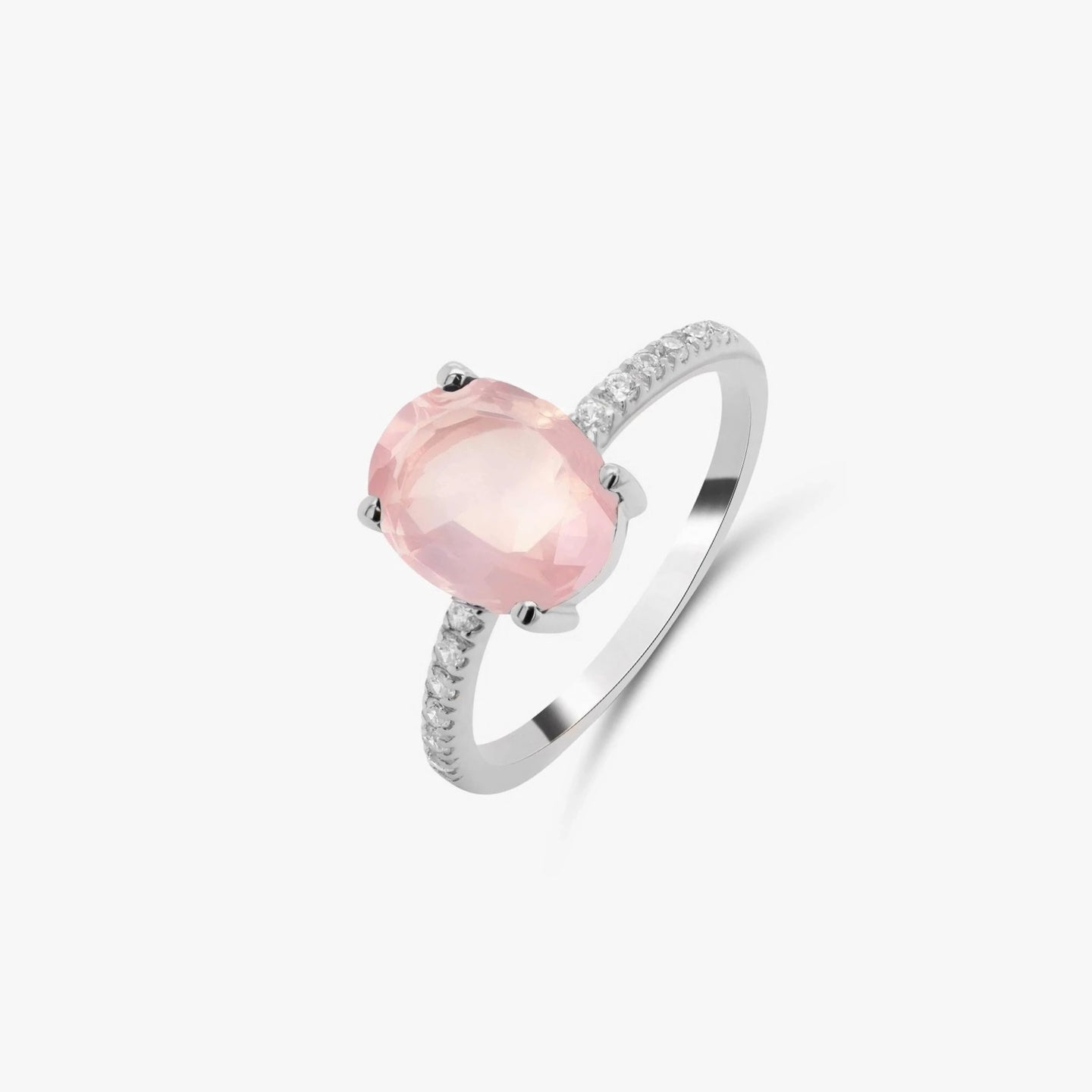 Bague en argent avec une pierre de quartz rose et de petites pierres de zirconium sur un fond blanc.