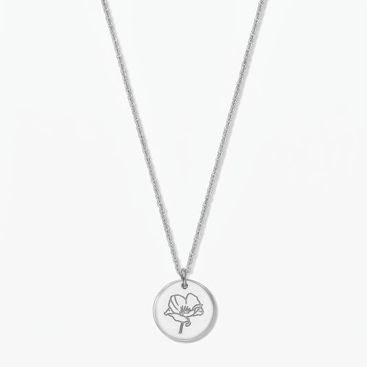 Collier fleur de naissance en argent sterling avec pendentif disque rond gravé d’un coquelicot, présenté au centre sur fond blanc.