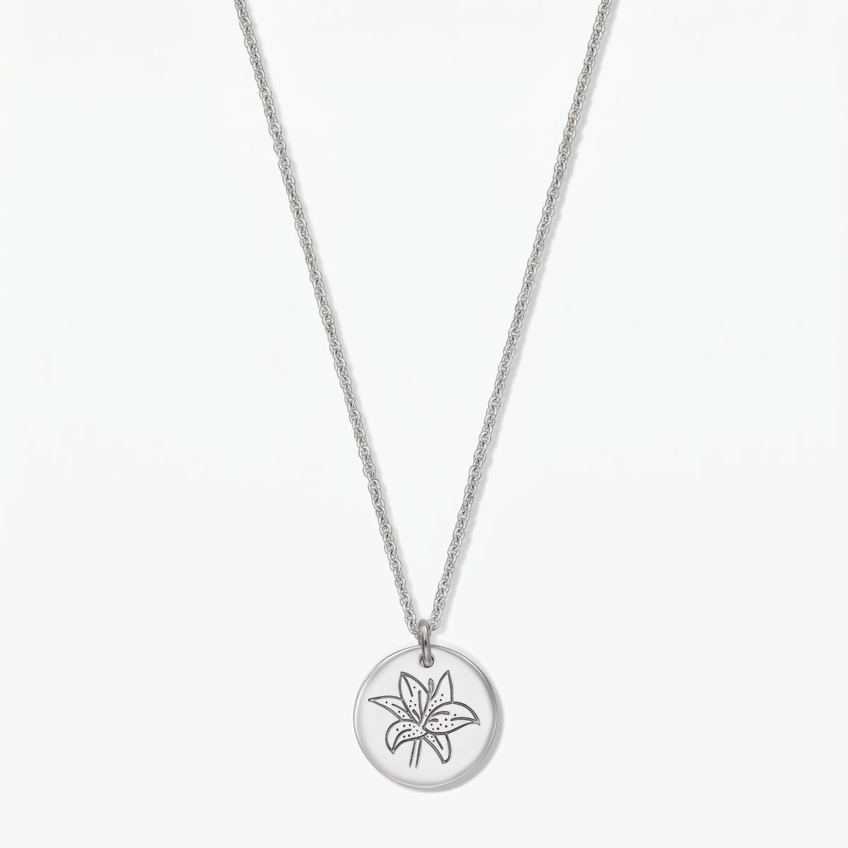 Collier fleur de naissance en argent sterling avec pendentif disque rond gravé d’un lys (mai), présenté sur fond blanc.