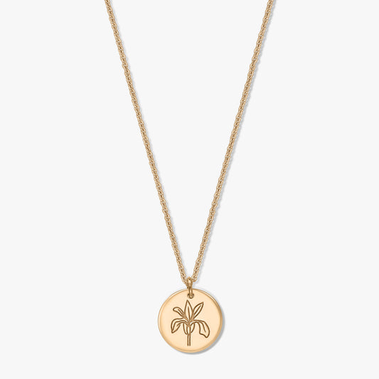 Collier fleur de naissance ton doré avec pendentif rond gravé d’un iris, sur une chaîne délicate, isolé sur fond blanc.