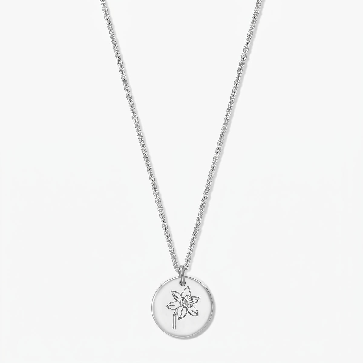 Collier en argent sterling avec pendentif rond gravé d'une jonquille (fleur de naissance de mars) sur fond blanc.