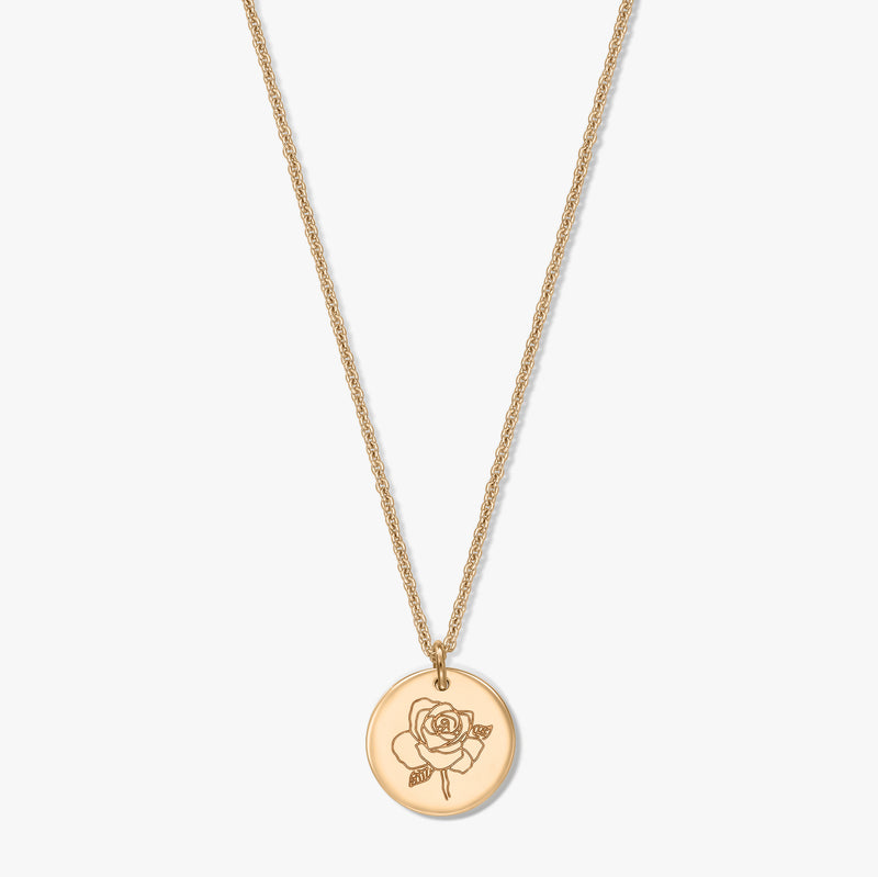 Collier en argent plaqué or avec un médaillon rond gravé d'une rose, photographié au centre sur fond blanc.