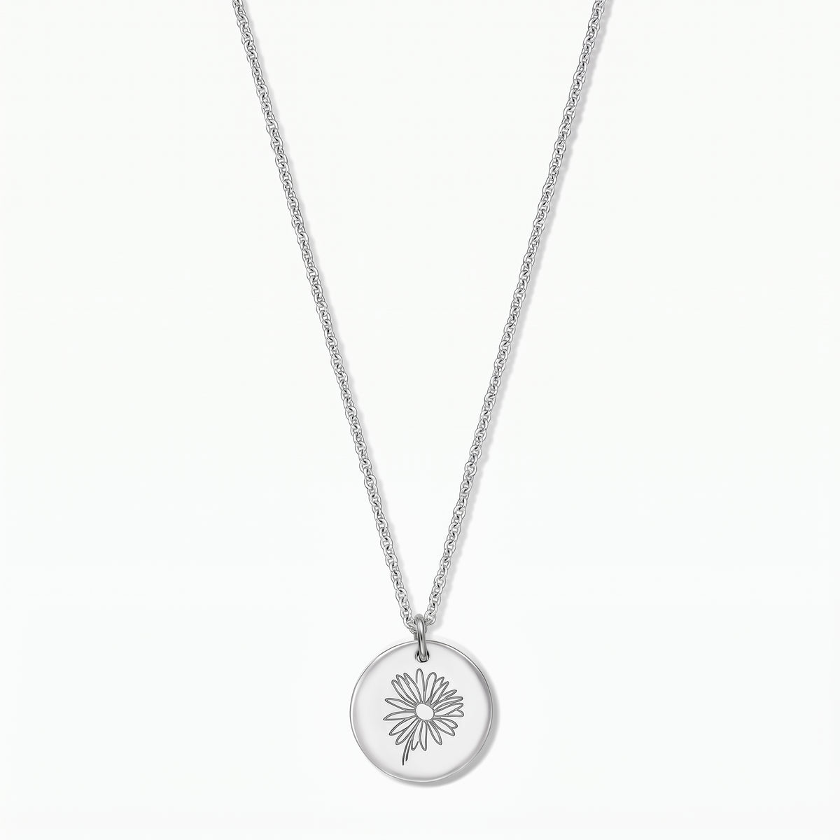 Collier en argent sterling avec un pendentif disque rond gravé d'une marguerite, photographié sur fond blanc.