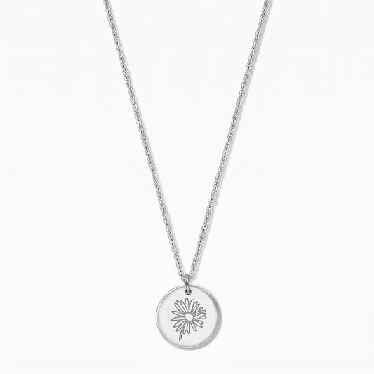 Collier en argent sterling avec un pendentif disque rond gravé d'une marguerite, photographié sur fond blanc.