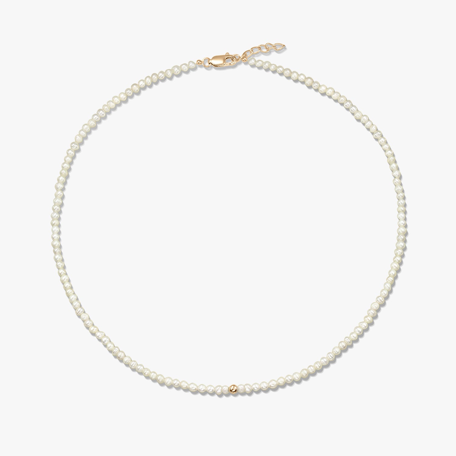 Image produit au format carré d’un collier délicat de perles naturelles, orné d’une petite bille en or jaune 14K, avec un fermoir mousqueton en or jaune et une courte chaînette d’extension, sur fond blanc.