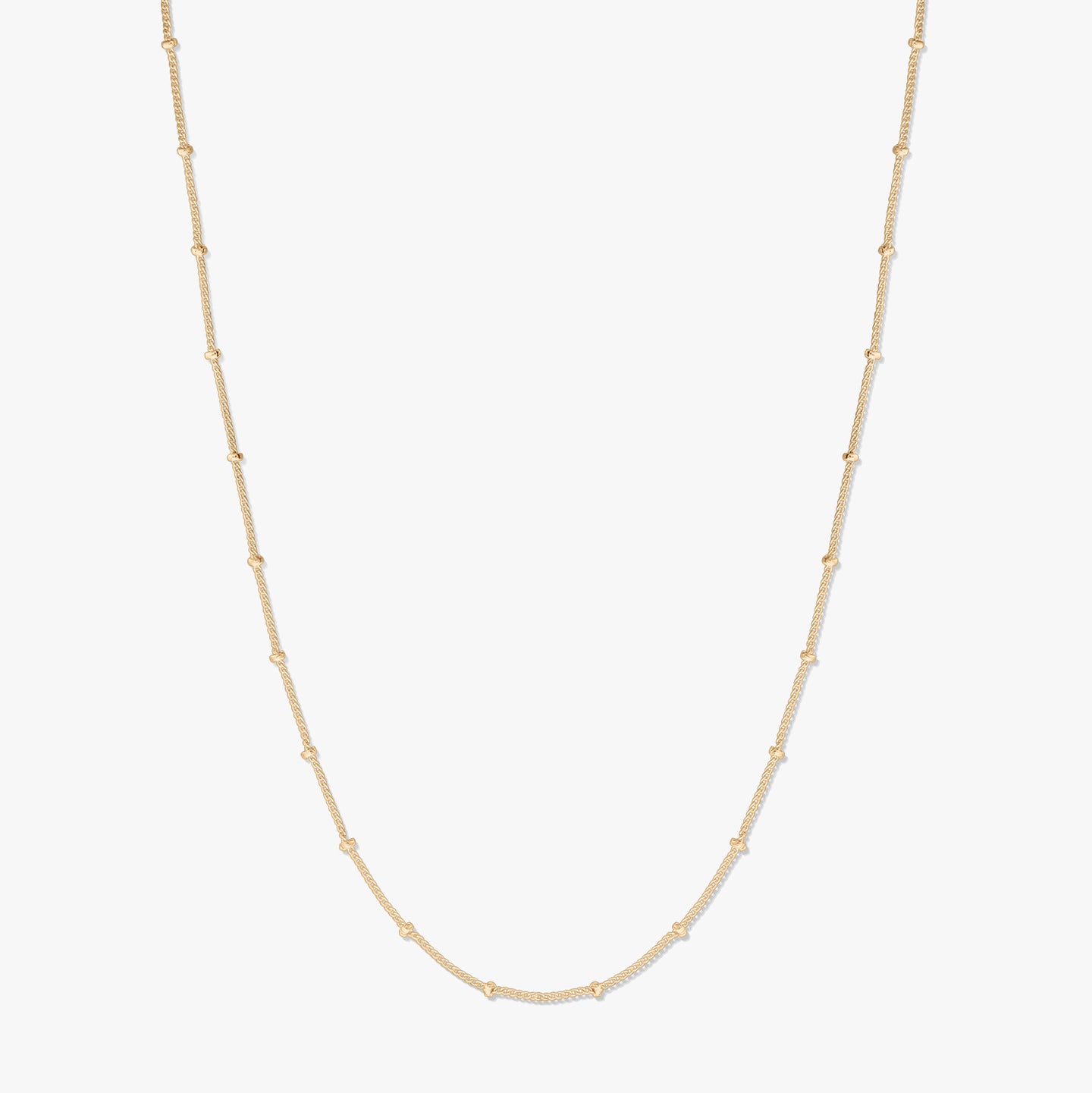 Collier chaîne en argent plaqué or, présenté sur fond blanc, formant une douce forme en U avec de petites perles espacées le long de la chaîne.