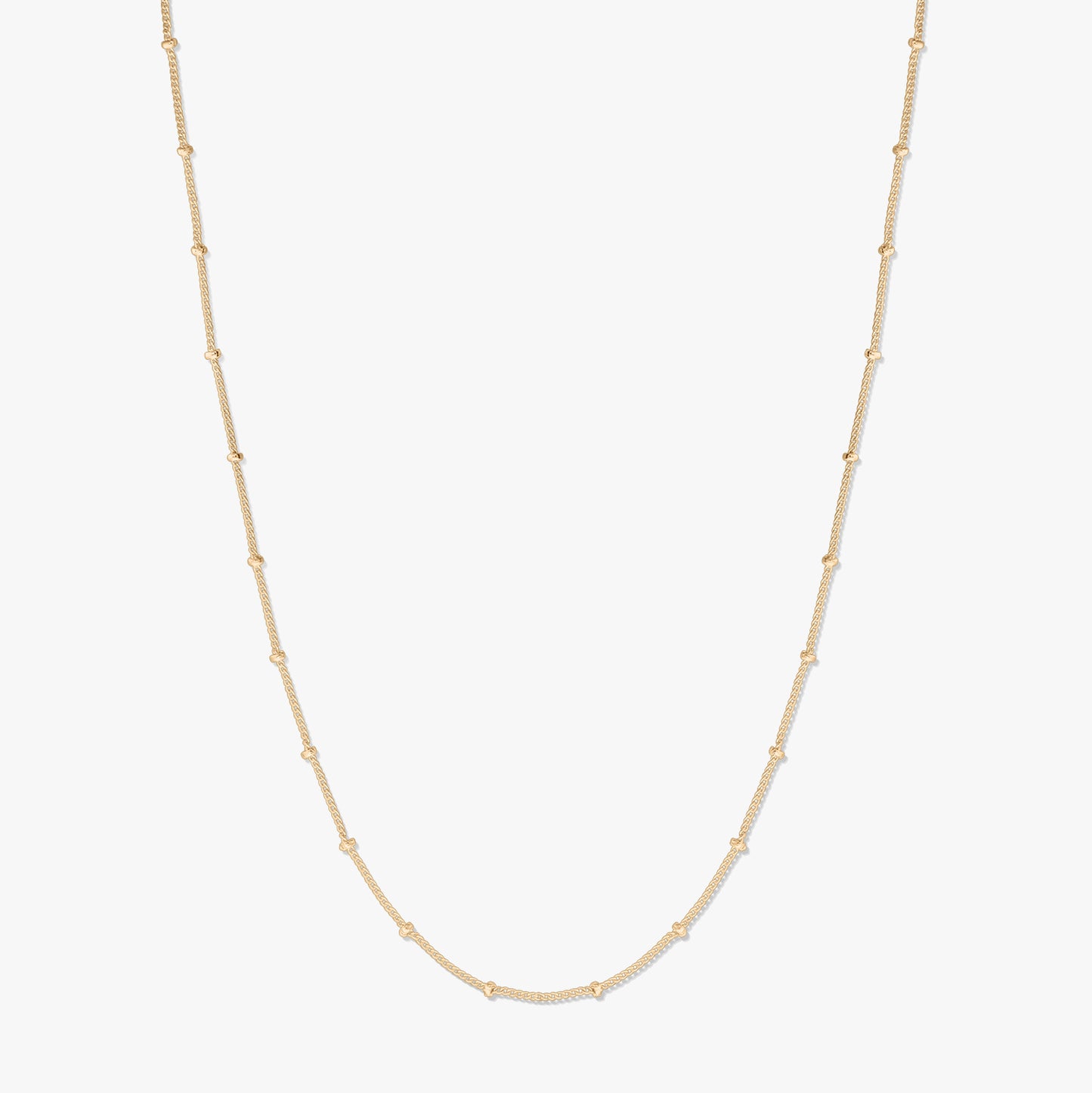 Collier chaîne en argent plaqué or, présenté sur fond blanc, formant une douce forme en U avec de petites perles espacées le long de la chaîne.