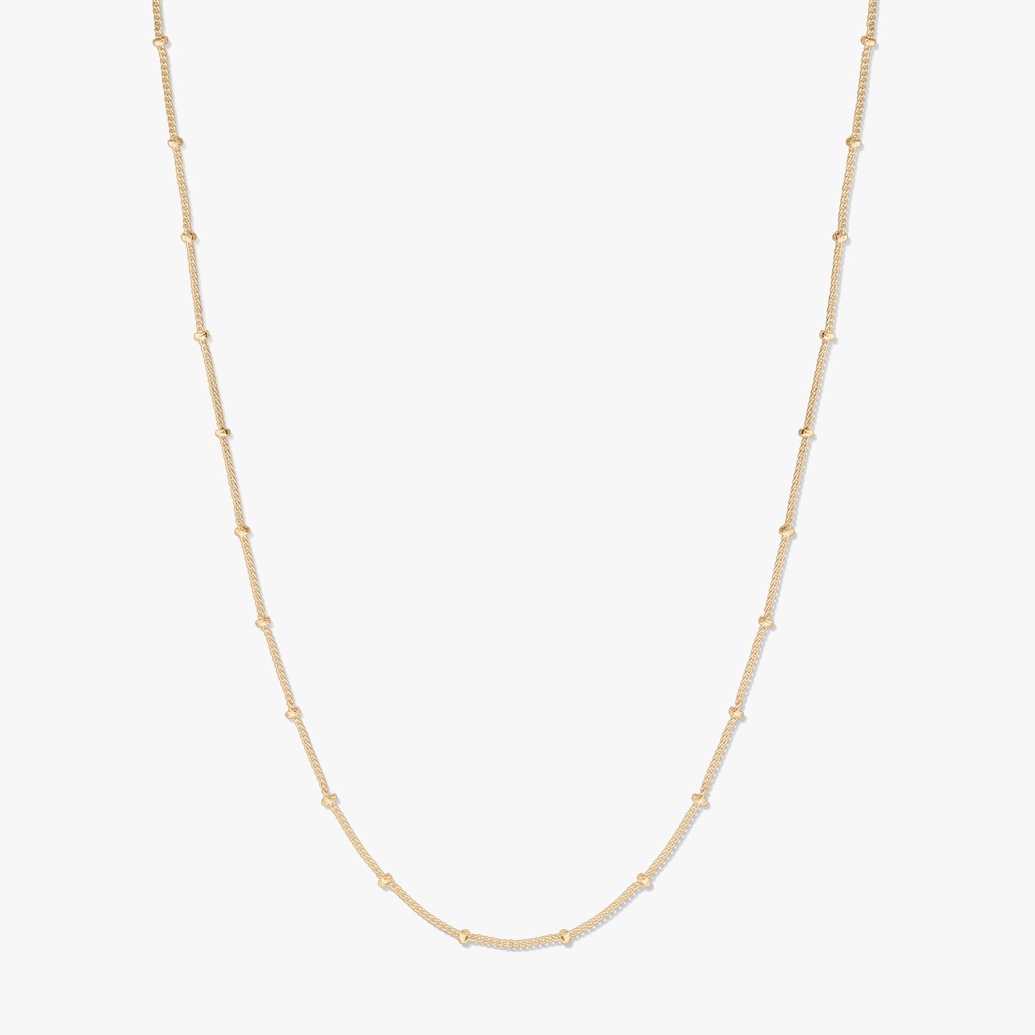 Collier chaîne en argent plaqué or, présenté sur fond blanc, formant une douce forme en U avec de petites perles espacées le long de la chaîne.