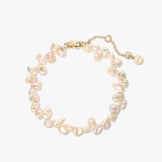 Bracelet en argent sterling plaqué or orné de perles keshi roses naturelles, avec chaîne de rallonge, sur fond blanc.