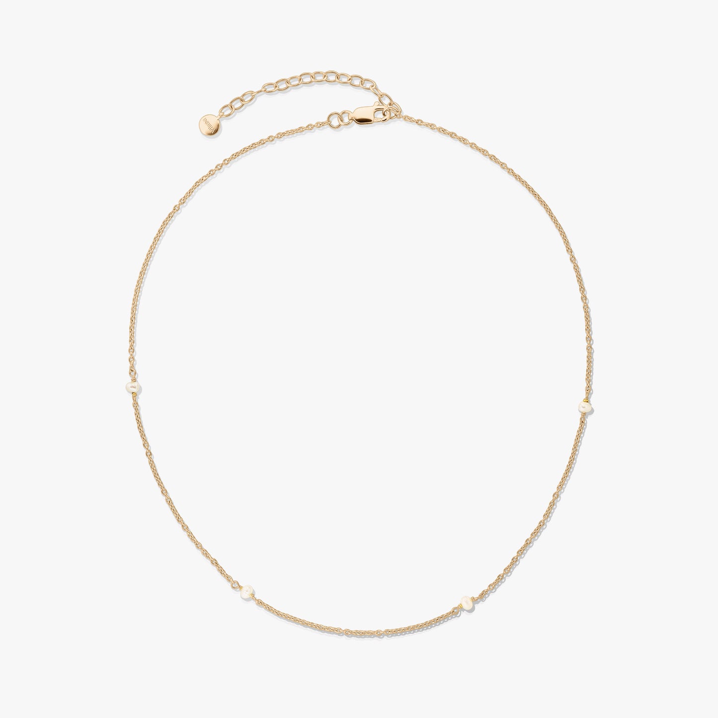 Collier délicat en argent 925 plaqué or avec de petites perles naturelles et une rallonge réglable avec fermoir mousqueton, sur fond blanc.
