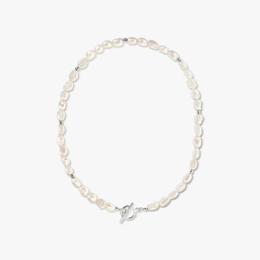 Photo de studio centrée d'un collier en argent à fermoir T (toggle) avec des perles baroques blanches naturelles sur fond blanc uni.