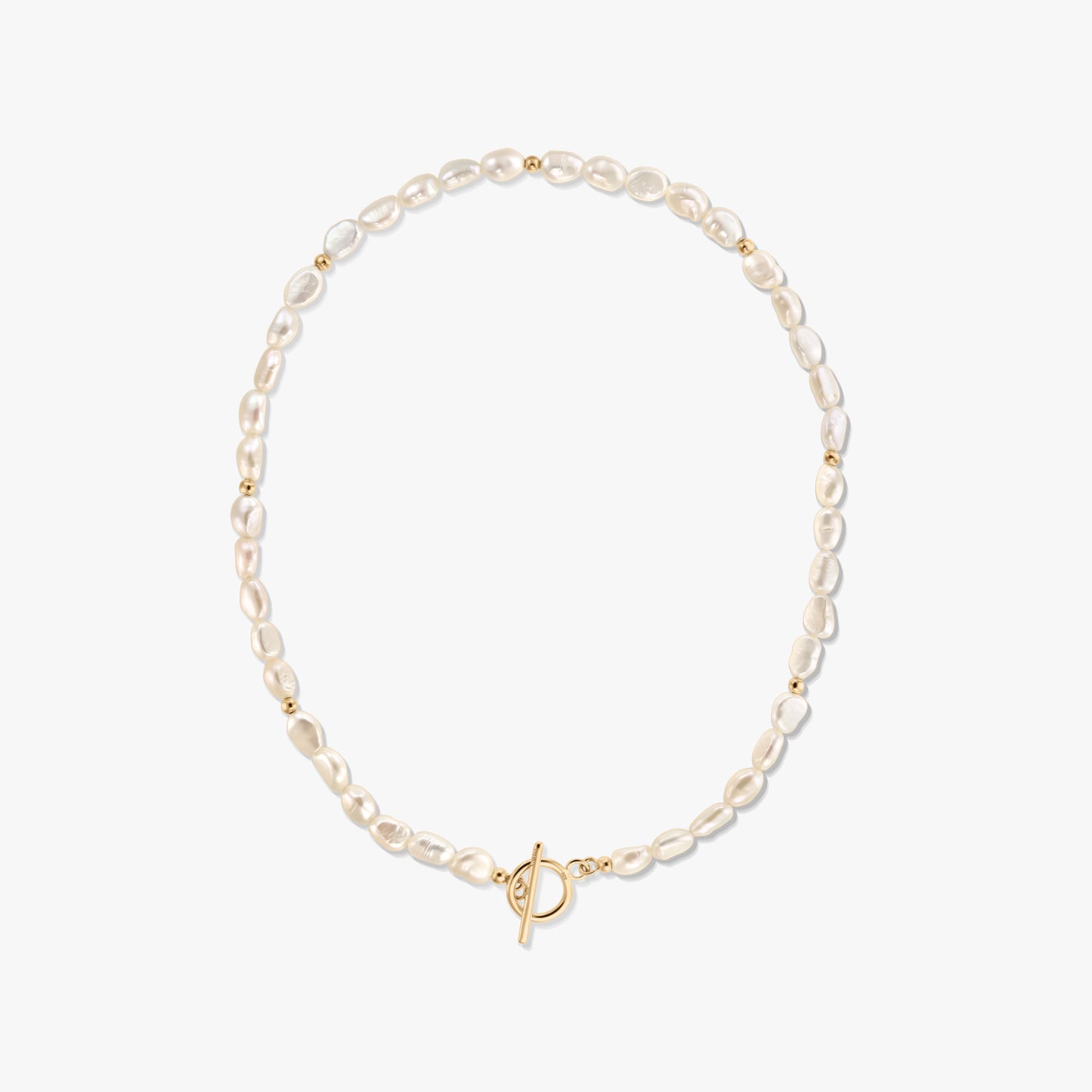 Photo studio d’un collier à rang de perles blanches naturelles, agrémenté de petites perles dorées et d’un fermoir toggle en or, sur fond blanc.