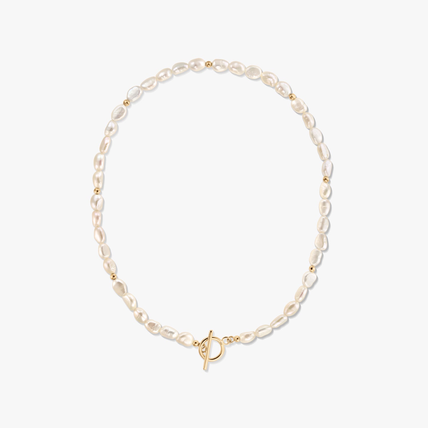 Photo studio d’un collier à rang de perles blanches naturelles, agrémenté de petites perles dorées et d’un fermoir toggle en or, sur fond blanc.
