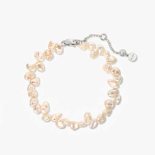 Photo de studio carrée d'un bracelet en argent rhodié orné de perles keshi d'eau douce roses irrégulières, présenté en cercle sur fond blanc, avec chaîne réglable et fermoir mousqueton.