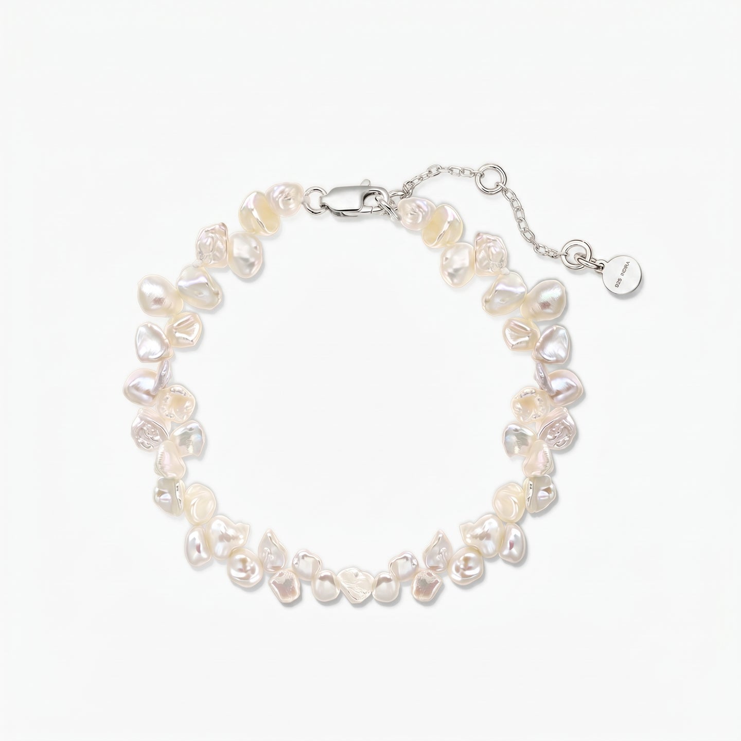 Bracelet ajustable en perles keshi d’eau douce, doté d’un fermoir mousqueton en argent 925 plaqué rhodium et d’une chaîne d’extension, sur fond blanc.