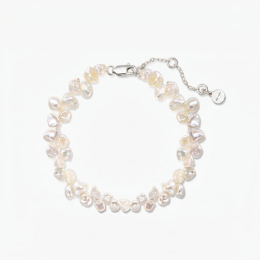 Bracelet ajustable en perles keshi d’eau douce, doté d’un fermoir mousqueton en argent 925 plaqué rhodium et d’une chaîne d’extension, sur fond blanc.